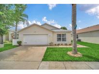 Charming single-story home featuring a two-car garage and well-maintained lawn at 941 Clear Creek Cir, Clermont, FL 34714