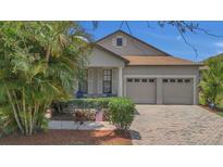 Charming home features a well-manicured lawn, neutral paint, shutters, and an attached two-car garage at 9836 Lake District Ln, Orlando, FL 32832