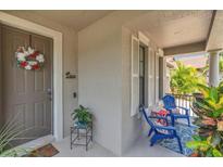 Inviting front porch with stylish door wreath and comfortable blue chairs at 9836 Lake District Ln, Orlando, FL 32832