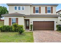 Charming two-story home with brown shutters and brick driveway at 1165 Stratton Ave, Groveland, FL 34736