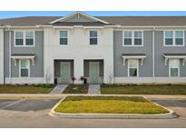 Charming townhome with light gray siding, white accents, and manicured landscaping at 1283 Blue Paradise Way, Clermont, FL 34714
