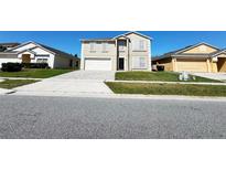 Charming two-story home with a well-manicured lawn and a paved driveway, reflecting curb appeal at 13046 Prairie Meadows Dr, Orlando, FL 32837