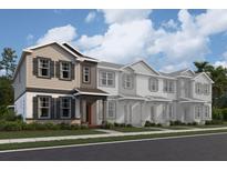 Charming townhome featuring neutral siding, black shutters, covered entry and manicured landscaping at 1403 Mount Royal Dr, St Cloud, FL 34771