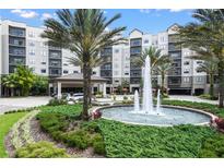 Stunning exterior view of a multi-story resort building with fountain, lush landscaping, and well-maintained lawns at 14501 Grove Resort Ave # 3636, Winter Garden, FL 34787