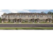 Charming townhome exterior with neutral colors, well-manicured lawn, and inviting curb appeal at 17081 Water Spring Blvd, Winter Garden, FL 34787