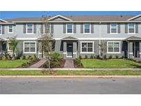 Charming townhome featuring a well-manicured lawn, gray shutters, and a covered entrance at 17081 Water Spring Blvd, Winter Garden, FL 34787