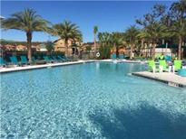 Resort-style pool with lounge chairs and palm trees creating a relaxing outdoor living space at 2660 Santosh Cv, Kissimmee, FL 34746