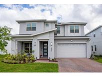 Beautiful two-story home featuring a covered front porch, a well-manicured lawn, and an attached two-car garage at 2841 Willowseed Ln, St Cloud, FL 34772