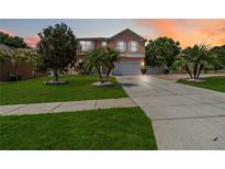 Charming two-story home with lush landscaping, palm trees, and a spacious driveway at 294 Hunt St, Clermont, FL 34711