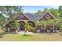 Charming single-Gathering home featuring a well-manicured lawn, mature trees, and a covered front porch at 549 Wellon Ave, Orlando, FL 32833