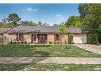 Charming brick home with a well-maintained front yard and red shutters offers classic curb appeal at 620 Fruitwood Ave, Winter Springs, FL 32708