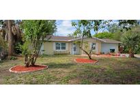 Charming single-story home features a manicured lawn with freshly mulched trees at 7600 Skyview Dr, Orlando, FL 32809