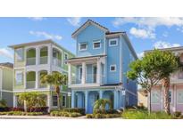 Charming three-story cottage with blue siding, white trim, and a welcoming front porch at 8045 Lost Shaker Ln, Kissimmee, FL 34747