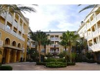View of a courtyard area with garden and fountain surrounded by yellow buildings with balconies at 860 N Orange Ave # 371, Orlando, FL 32801