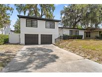 Two-story home with a 2-car garage, dark trim and a concrete driveway at 913 Moss Ln, Winter Park, FL 32789