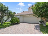 Charming single-Gathering home featuring a tile roof, brick driveway, and lush landscaping at 939 Glen Abbey Cir, Winter Springs, FL 32708