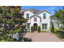 Charming two-story home featuring a well-manicured lawn and a brick driveway at 14962 Fells Ln, Orlando, FL 32827