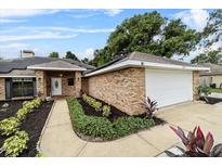 Charming single-story brick home featuring well-manicured landscaping and a two-car garage at 157 Ambergate Ct, Debary, FL 32713
