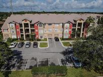 Apartment complex with colorful exterior, parking, and beautiful landscaping at 2208 Antigua Pl # 932, Kissimmee, FL 34741