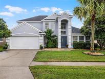 Charming two-story home featuring a well-manicured lawn, a two-car garage, and attractive landscaping at 408 Becky St, Orlando, FL 32824