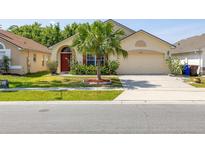 Charming single-story home featuring a well-manicured lawn and a decorative palm tree in the front yard at 4640 Eagle Peak Dr, Kissimmee, FL 34746