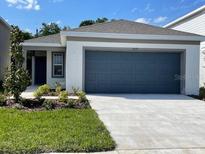 Charming one-story home featuring a two-car garage, well-manicured lawn, and beautiful landscaping at 5079 Royal Point Ave, Kissimmee, FL 34746