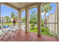 View of the outdoor balcony with table and chairs, overlooking the building's landscaped yard at 514 Orange Dr # 31, Altamonte Springs, FL 32701