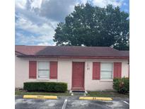 Charming single-story home with a red door, red shutters and a well-manicured lawn at 53 W Marbrisa Way, Kissimmee, FL 34743