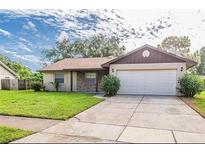Charming home with a well-maintained front yard, attached garage and covered entry at 5311 Ansonia Ct, Orlando, FL 32839