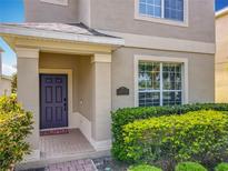 Inviting home featuring a classic purple front door and manicured shrubbery at 5772 Laurel Cherry Ave, Winter Garden, FL 34787