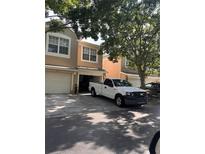 Townhome exterior view showcasing attached garages and neutral-colored facade at 6450 Alcalde Ct # 106, Orlando, FL 32835