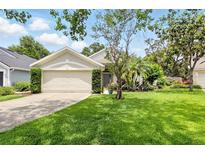 Well-maintained home featuring a two-car garage, lush green lawn, and mature landscaping for enhanced curb appeal at 811 Wayne Ave, Altamonte Springs, FL 32701