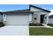 Charming single-story home with a two car garage, stone accents, and a well-manicured lawn at 1392 Dalkeith Cv, Sanford, FL 32771