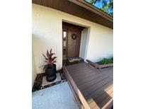 Inviting front door with welcome mat and decorative wreath, complemented by a charming wooden walkway and lush greenery at 1880 N Crystal Lake Dr # 3, Lakeland, FL 33801