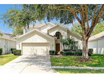 Charming two-story home with a well-maintained lawn, mature trees, and a two-car garage at 2648 Daulby St, Kissimmee, FL 34747