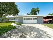 Charming home featuring a large garage, well-manicured lawn, and inviting curb appeal on a sunny day at 2736 Shannon Rd, Orlando, FL 32806