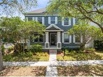 Charming two-story home featuring a beautifully landscaped front yard with mature trees and inviting walkway at 3813 Goldenglow Dr, Orlando, FL 32828