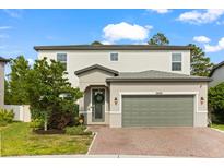 Two story home with a two car garage, brick paver driveway, manicured lawn, and neutral color palette at 5458 Carrara Ct, St Cloud, FL 34771