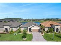 Charming single-story home with a brick driveway and well-manicured lawn near a serene lake at 636 San Augusto Dr, Kissimmee, FL 34759