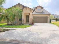 Charming single-Gathering home featuring a two-car garage, manicured lawn, and welcoming front porch at 6728 Duncaster St, Windermere, FL 34786