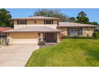 Charming two-story home with stone accents, well-manicured lawn, and inviting front entrance at 721 Fairway Dr, New Smyrna Beach, FL 32168