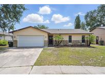 Charming single-story home features a well-maintained lawn, two car garage, and decorative stone accents at 2527 Christine Dr, Kissimmee, FL 34744