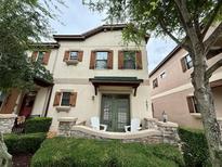 Charming townhome featuring shutters, stone accents, and a cozy front porch at 10631 Village Lake Rd, Windermere, FL 34786