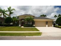 Charming single-story home with a three car garage, manicured lawn, and lush landscaping at 13016 Islamorada Dr, Orlando, FL 32837