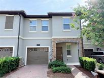 Charming townhome featuring a single-car garage, and brick-paver walkway nestled in a serene, landscaped neighborhood at 1308 Shinnecock Hills Dr, Davenport, FL 33896