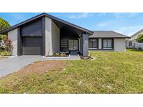 Charming single-story home featuring dark accents, a well-manicured lawn, and a welcoming entrance at 17 S Flag Ct, Kissimmee, FL 34759