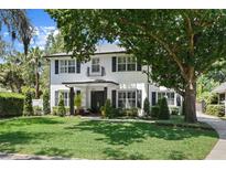 Beautiful two-story home featuring a manicured lawn and charming front porch with black shutters at 2339 Lafayette Ave, Winter Park, FL 32789