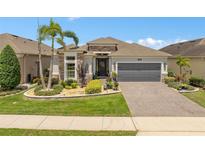 Charming single-story home featuring a well-manicured lawn and a two-car garage at 2554 Stargrass Cir, Clermont, FL 34715