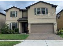 Charming two-story home with a two-car garage, manicured lawn and beautifully landscaped front yard at 2793 Mead Ave, St Cloud, FL 34771