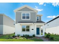 Charming two-story home featuring a modern design, gray siding, white accents and a welcoming blue front door at 6328 Whip O Will Ln, St Cloud, FL 34771